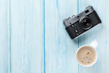 Travel camera and coffee cup on wooden table