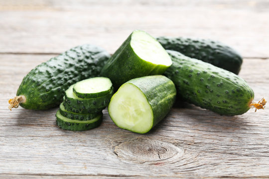 Fresh cucumbers on grey wooden background
