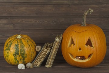 Halloween pumpkin head on wooden background. Preparing for Halloween. Head carved from a pumpkin on Halloween. Pumpkin tradition. The book of spells, magical book.  Textbooks for witches. 
