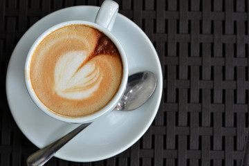 Cup of delicious foamy cappuccino on the black background