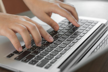 Fototapeta na wymiar Closeup of business woman hand typing on laptop keyboard