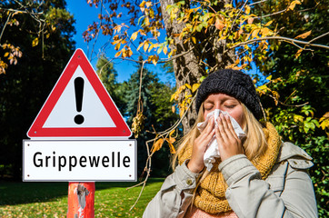 Achtung Grippewelle Schild mit junger Frau