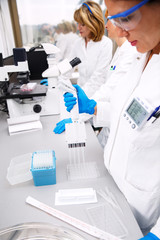 Photo of three real female scientists researching in laboratory.