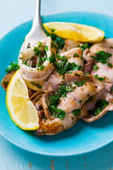 grilled calamary a grill with parsley and a lemon