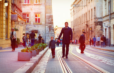 fashionable father and son walking in old city street