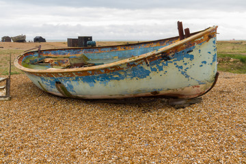 Old derelict boat on pebble beach.