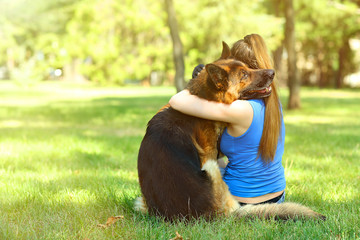 Beautiful young girl with dog in park