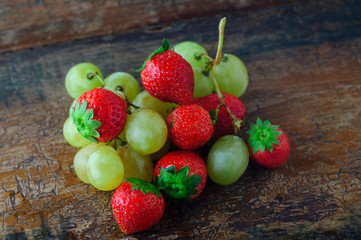 Fragole rosse su tavolo antico sfondo legno, frutta fresca di stagione autunnale