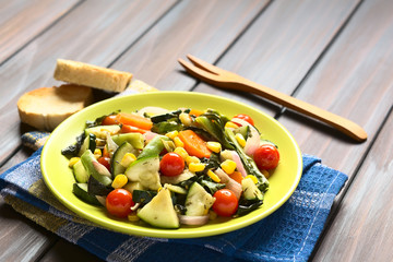 Baked vegetables (zucchini, onion, cherry tomato, broccoli, carrot, sweet corn, green bean, chard) seasoned with thyme, photographed with natural light (Selective Focus, Focus one third into dish)