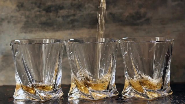 Pouring whiskey in three glasses