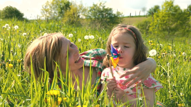 Mutter und Tochter kuscheln und spielen zusammen in einer Fr&uuml;hlingswiese - Teil 2