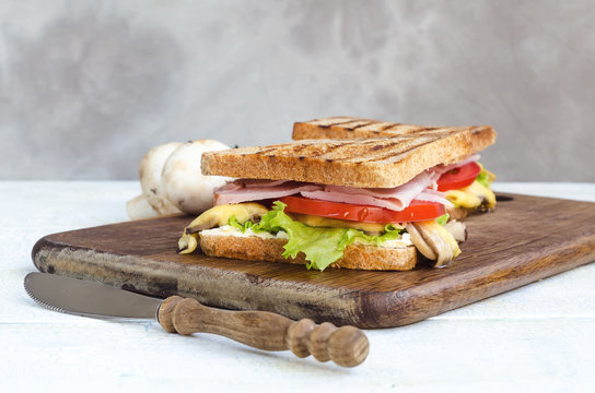 Tasty healthy sandwiches at white wooden table. Rustic style.