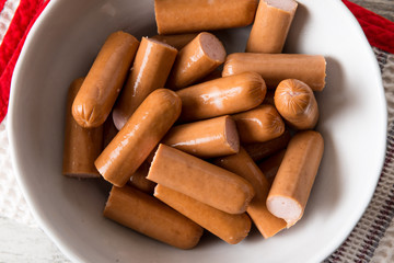 Würstel  tagliati in un contenitore di ceramica bianca su un tavolo