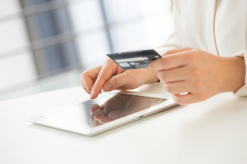 Hands of an office woman typing keyboard with credit card