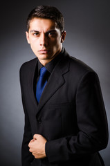 Young elegant man against gray