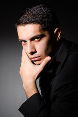 Young businessman in dark studio