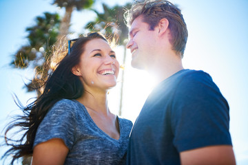 Fototapeta premium happy romantic couple outside on sunny day with palm trees