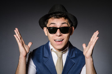 Naklejka premium Young man in blue vest and hat against gray