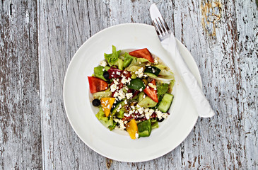 White plate of delicious vegetable salad on wooden table.Tasty