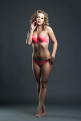 Fototapeta na wymiar Smiling blonde posing in pink bra and panties