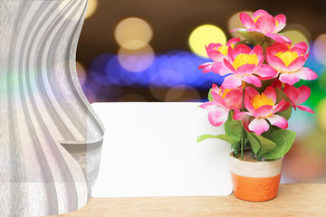 white drapery on white card and flower vase with bokeh light