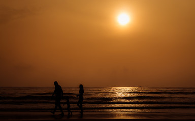 Fototapeta premium Silhouette people walking on the beach