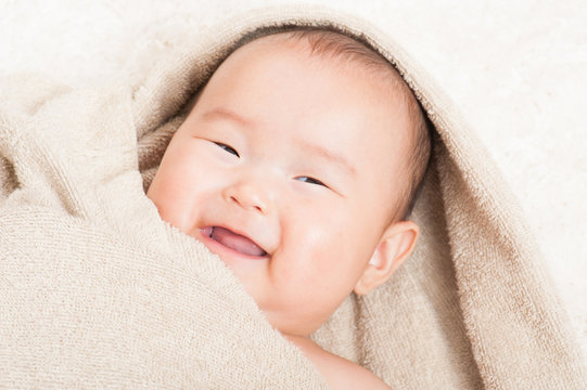 タオルの中で笑顔の赤ちゃん