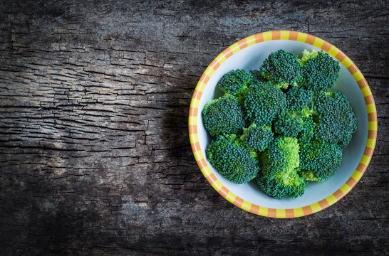 Top view. Fresh green broccoli on plate over wooden background.