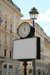 Fototapeta na wymiar Blank banner with clock on street in Italy