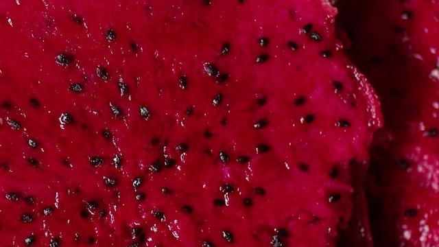 Macro overhead close up of a freshly cut red dragon-fruit in a bowl. Exotic Asian Dragon Fruit as seen in a series of Asian Nature and Agriculture