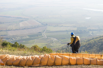 yellow paraglider pilot is starting aove the fields © tamaslaza3