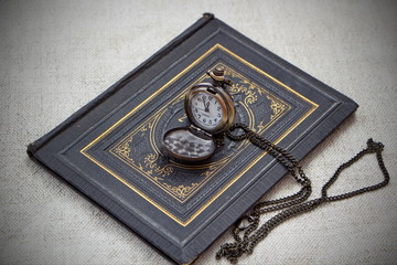 vintage still life with pocket watch and old book