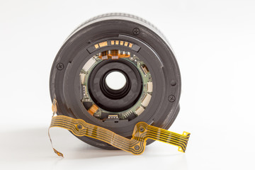 Lens and flat ribbon cable on white background