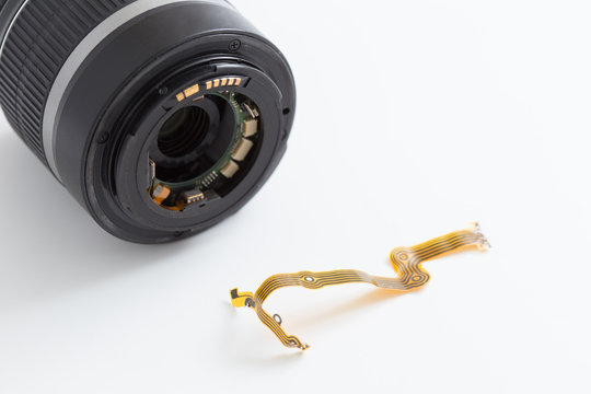 Lens and flat ribbon cable on white background