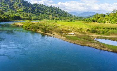 River behind the green field
