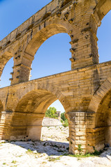Fototapeta na wymiar Arches of the aqueduct Pont du Gard, France. Aqueduct is included in the UNESCO World Heritage List