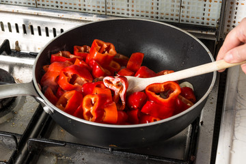 Rosolatura nel soffritto di rondelle di peperone rosso  nella pentola 