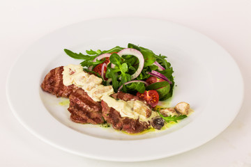 Grilled meat with sauce arugula cherry red onion plate white
