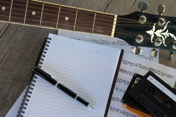 concept song composer: guitar, tape cassette, notebook, song notes and pen
