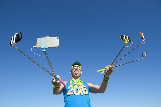 Gold medal 2016 athlete making a face for his many gadgets on selfie sticks as he poses for photos