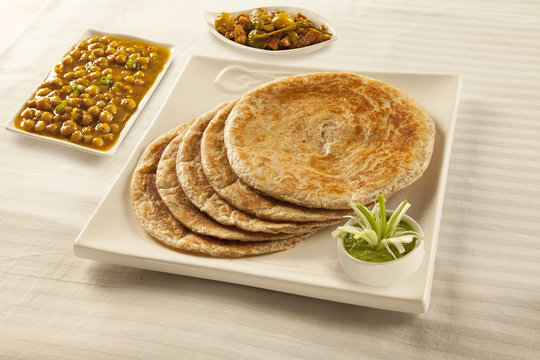 Bran paratha puri served with chickpeas cholay and pickle chutne