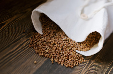 bag for storage of buckwheat on wooden background