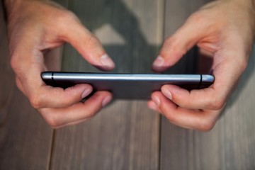 Person holding smartphone at desk