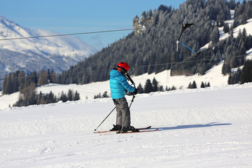 Fototapeta na wymiar kleiner Skifahrer am Schlepplift