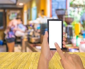 male hand is holding a modern touch screen phone and Coffee shop