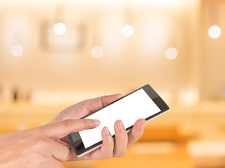 male hand is holding a modern touch screen phone and Coffee shop