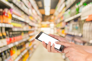 male hand is holding a modern touch screen phone and blurred ima