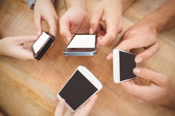 Overhead view of cropped hands using smartphones 