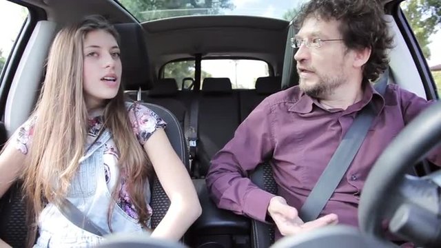 angry father driving and talking about problem with his young daughter