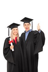 Delighted man and woman in graduation gowns